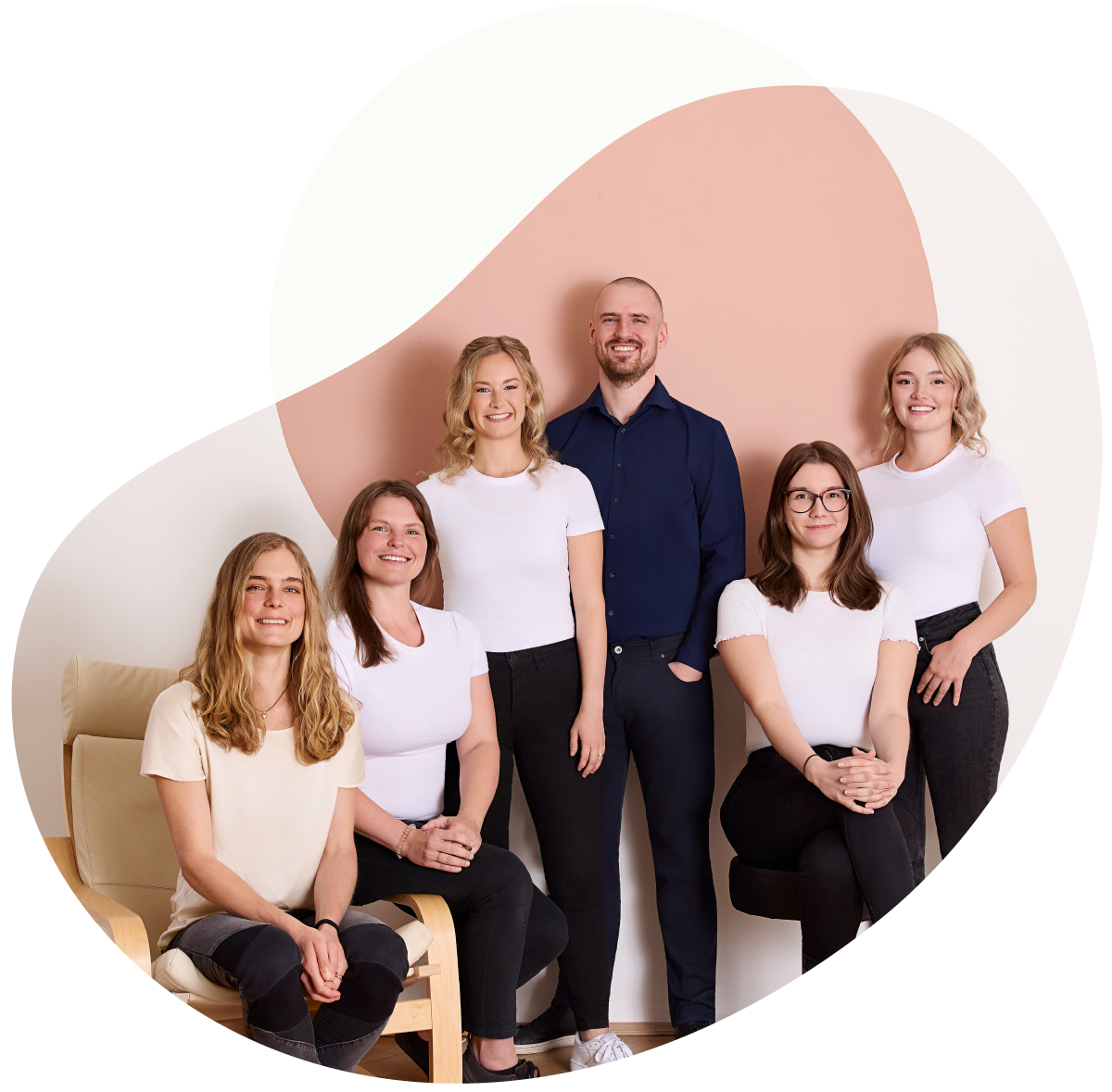 6 Menschen sehen in die Kamera und lächeln